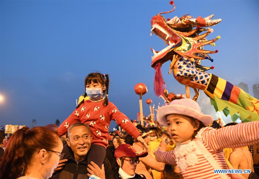 People perform dragon dance in flames of firecrackers in Guangxi