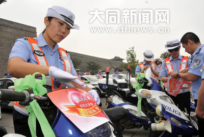 綜警隊員往車上粘送考車貼、捆綠絲帶