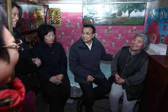 李克強考察棚戶區:彎腰坐上高低床