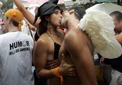 A couple of Carnival revelers kiss during the Ipanema Band street party as others mill about, in Rio de Janeiro, January 5, 2005. Brazilians of all walks of life danced, sang and partied together during the annual Carnival festivities. 