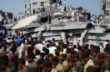 Pakistani army soldiers and rescue workers gather at the site of a building collapsed by an earthquake in Islamabad October 8, 2005.