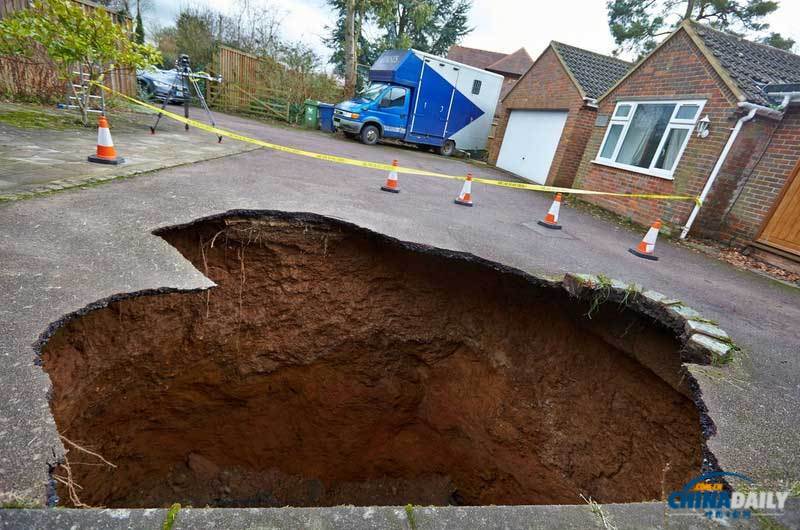 英國居民房屋前驚現大坑 汽車慘遭“吞噬”
