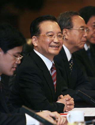 Chinese Premier Wen Jiabao (R) speaks to German Chancellor Angela Merkel after their meeting at the Great Hall of the People in Beijing May 22, 2006. China and Germany signed a batch of 19 agreements on the first day of Merkel's visit, including to build a high-speed rail system. [Reuters]