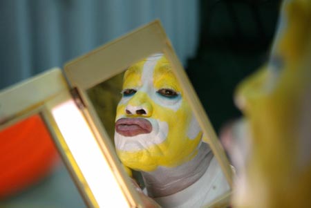 A clown paints his face as preparation for his performance at an international clown convention in Mexico City October 18, 2006. 