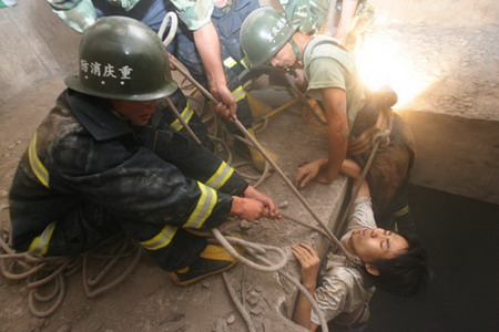 Firemen rescue Liu Jie, who was trapped in a bridge abutment for 26 hours, in Chongqing��July 16, 2006. Liu Jie fell into the abutment by accident and attracted people's attention by setting on his clothes on fire with a lighter. [Wang Yuanling/Chongqing Times]