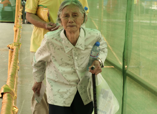 An aged woman waits to cast a vote on the demolishment and reconstruction of old buildings in Juixiaqiao Sub-district in Beijing, June 9, 2007. Local government and the real estate developer jointly organize the vote on Saturday to see if majority residents of over 5000 families accept the new compensation policy after failed attempts to reach an agreement through other ways. Both notary officials and supervisors are invited to monitor the vote that runs from 9 a.m. to 9 p.m. at six ballot booths. [Sun Yuqing/m.szjzcy.com]