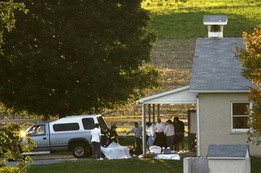 A body is carried from a schoolhouse, where a gunman killed several people, in Nickel Mines, Pa. on Monday, Oct. 2, 2006. A 32-year-old milk truck driver took about a dozen girls hostage in the one-room Amish schoolhouse Monday, barricaded the doors with boards and shot several people, killing at least threebefore committing suicide.