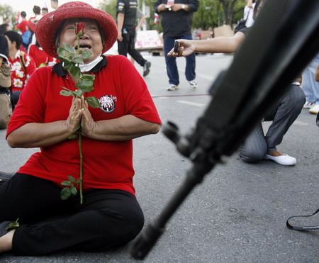 Thai troops surround protestors after 2 killed in clash